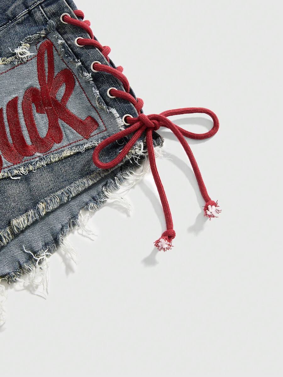 Women's Y2K low waist camo mini skort shorts featuring lace-up knot details, grommet eyelets, graphic lettering pattern, and a zipper fly.