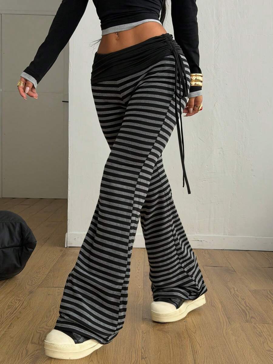 Women's striped flare leg pants featuring a mid-rise waist, slim fit thigh, and ruched side drawstring detail in stretch knit fabric.