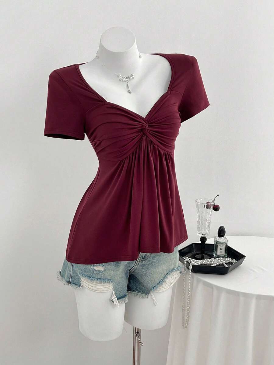 Women's short sleeve V-neck T-shirt featuring a front twist knot detail and slim fit.