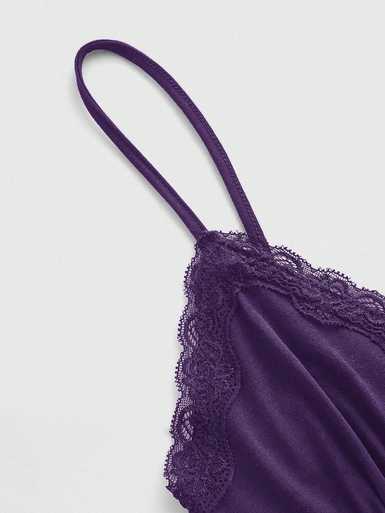 Women's spaghetti strap camisole with contrast lace patchwork, slim fit silhouette, plain design, and flared hem.