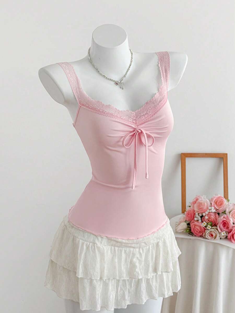 Women's slim fit casual camisole featuring wide shoulder straps, contrast lace trim, a front knot, and ruched details.