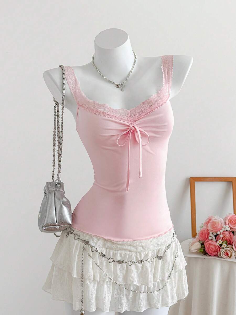 Women's slim fit casual camisole featuring wide shoulder straps, contrast lace trim, a front knot, and ruched details.