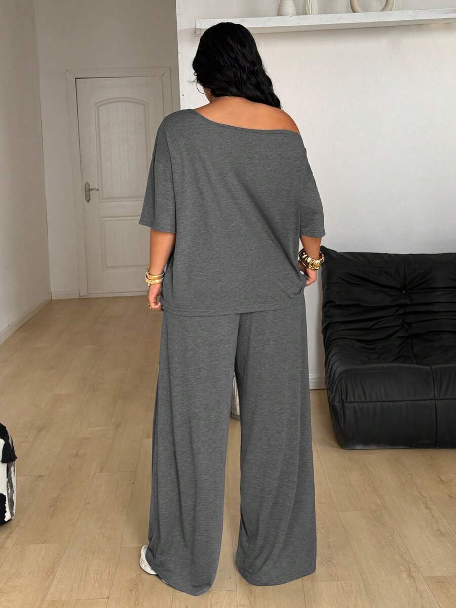 Women's casual two-piece outfit featuring a loose short-sleeve asymmetrical neck t-shirt and matching long wide leg pants with pockets.