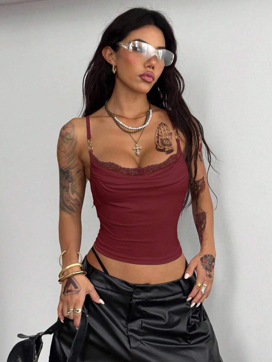 Women's black knit slim fit camisole top featuring contrast lace detailing, a backless design, ruched accent, and thin spaghetti straps.