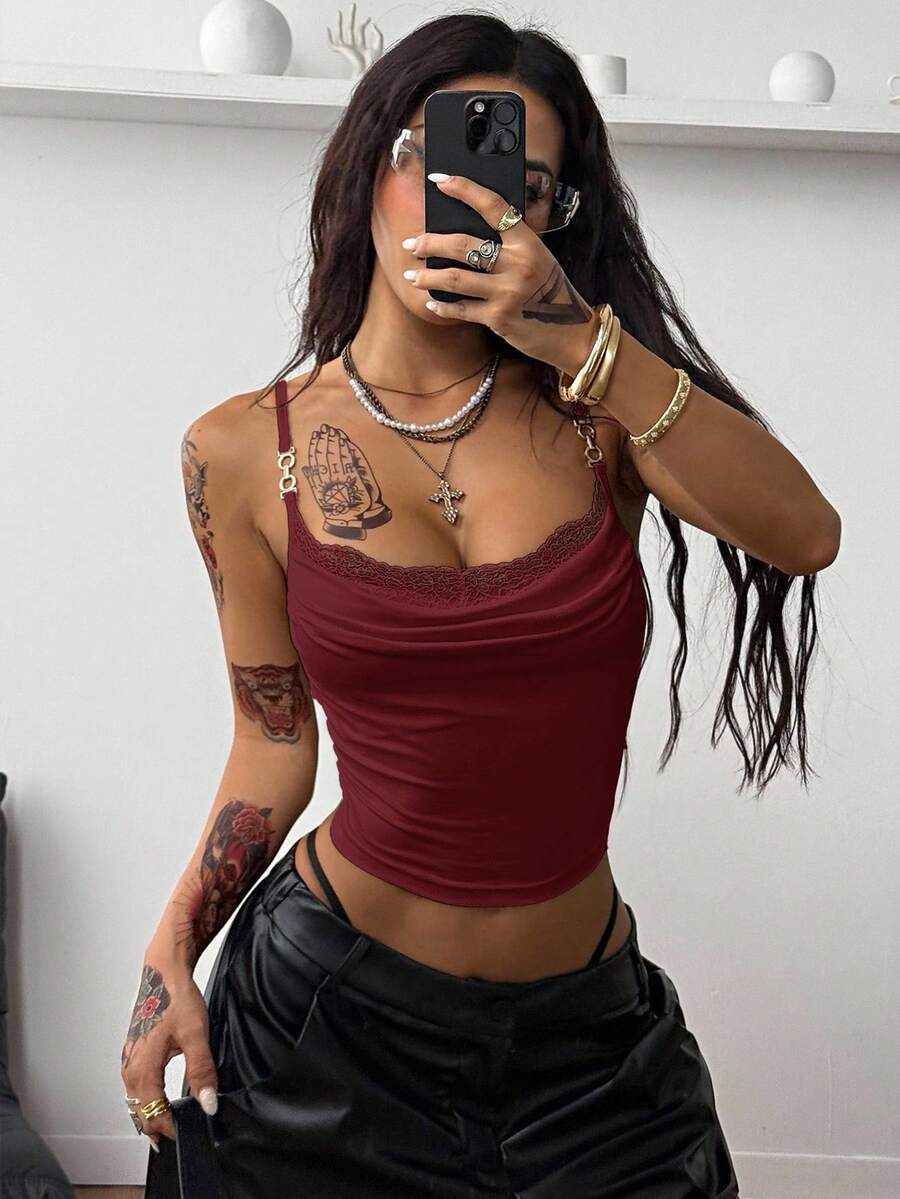 Women's black knit slim fit camisole top featuring contrast lace detailing, a backless design, ruched accent, and thin spaghetti straps.