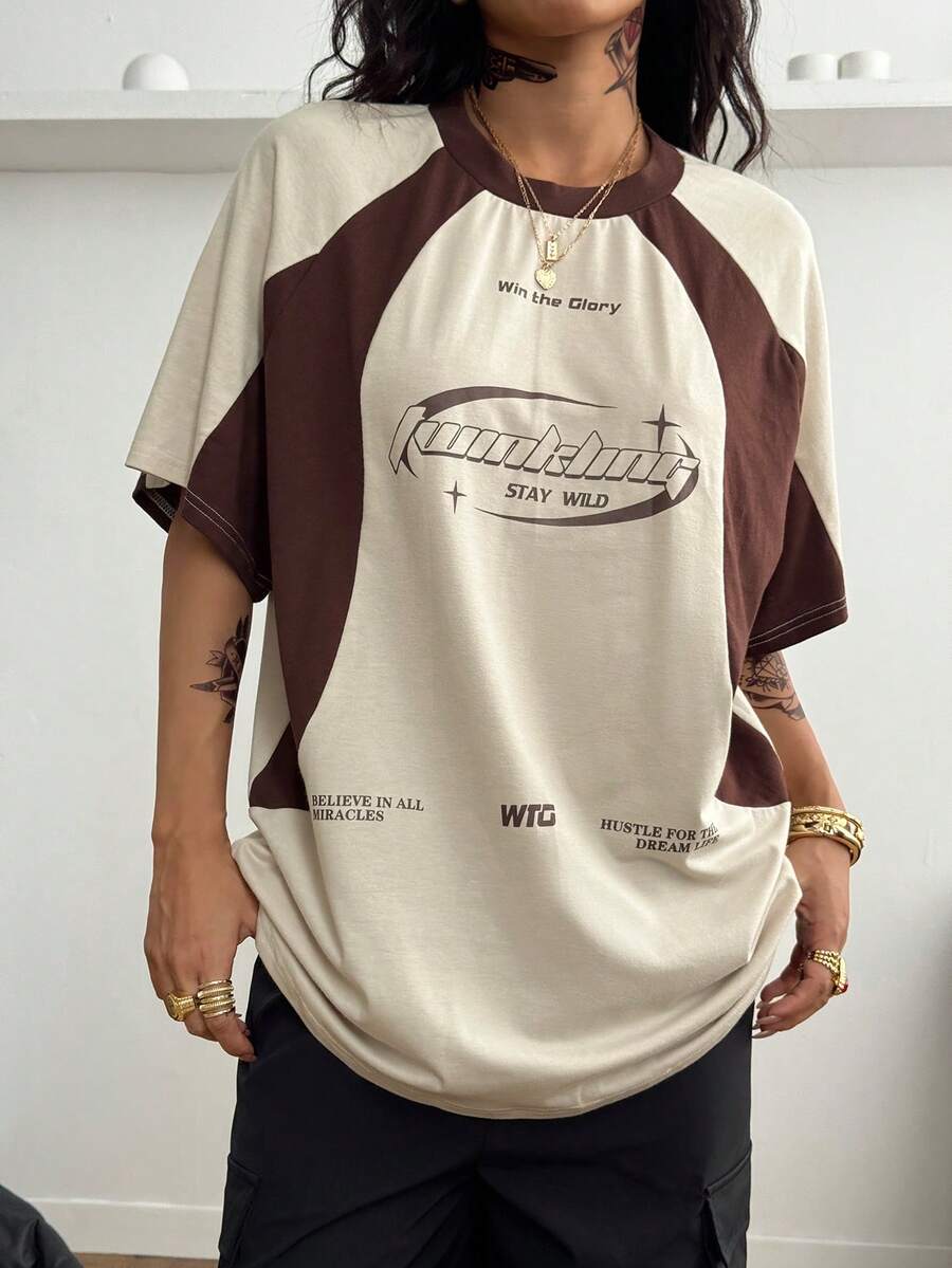 Unisex plus size oversized jersey t-shirt in brown featuring a round neck, short raglan sleeves with contrast binding, and a front letter graphic print.