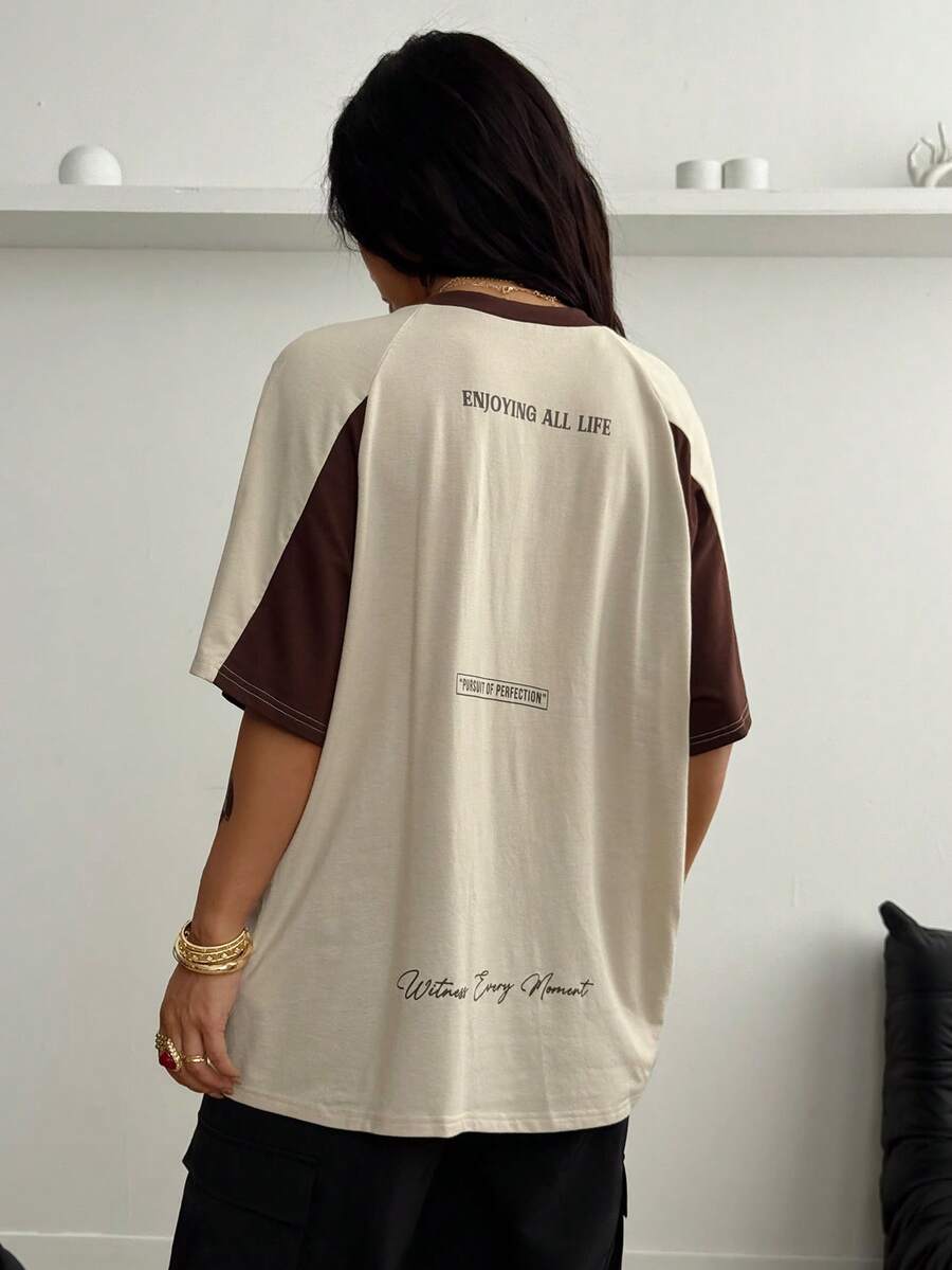 Unisex plus size oversized jersey t-shirt in brown featuring a round neck, short raglan sleeves with contrast binding, and a front letter graphic print.