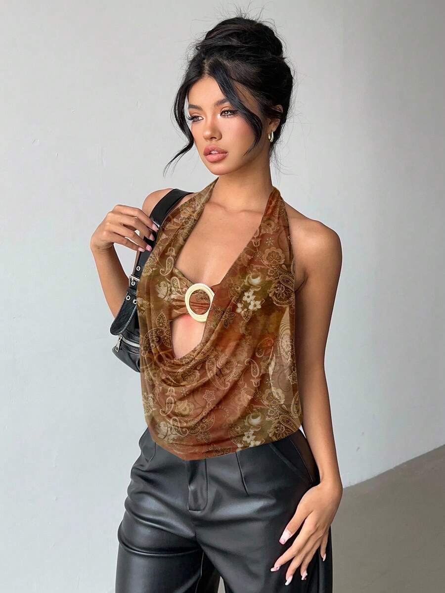 Brown and white polka dot semi-sheer halter camisole top with a plunging neckline, backless design, draped front, and metallic studded embellishments.