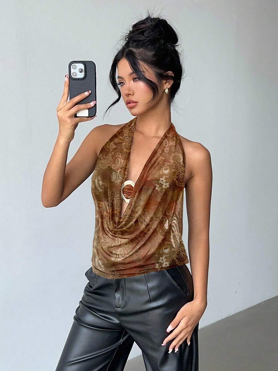 Brown and white polka dot semi-sheer halter camisole top with a plunging neckline, backless design, draped front, and metallic studded embellishments.