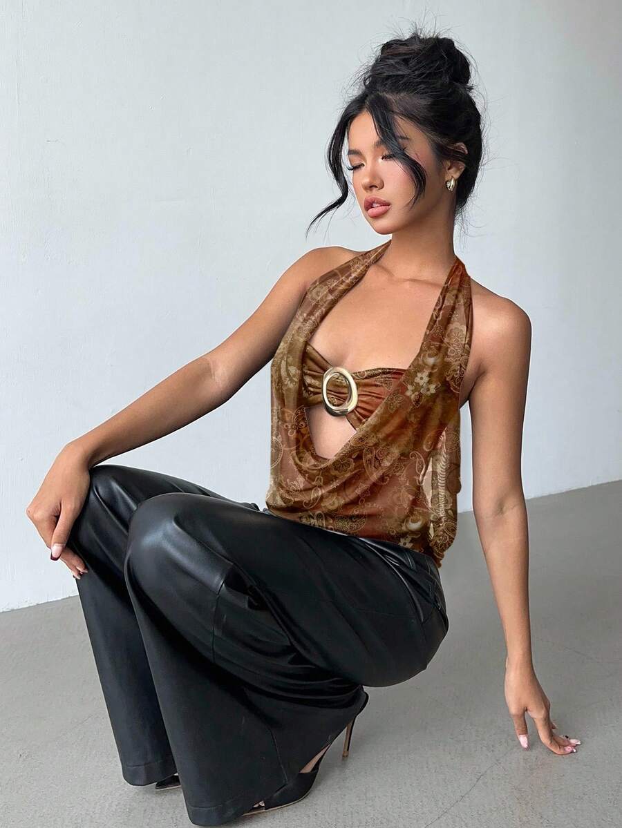 Brown and white polka dot semi-sheer halter camisole top with a plunging neckline, backless design, draped front, and metallic studded embellishments.