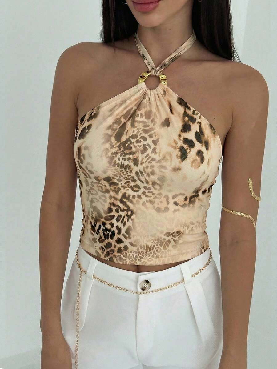 Women's black backless halter mesh crop top featuring knot and ring details with matching arm sleeves.