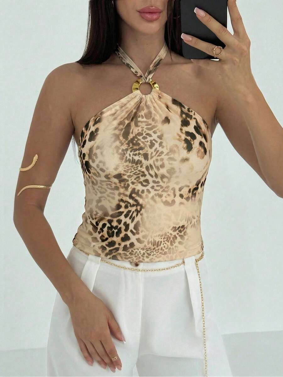 Women's black backless halter mesh crop top featuring knot and ring details with matching arm sleeves.