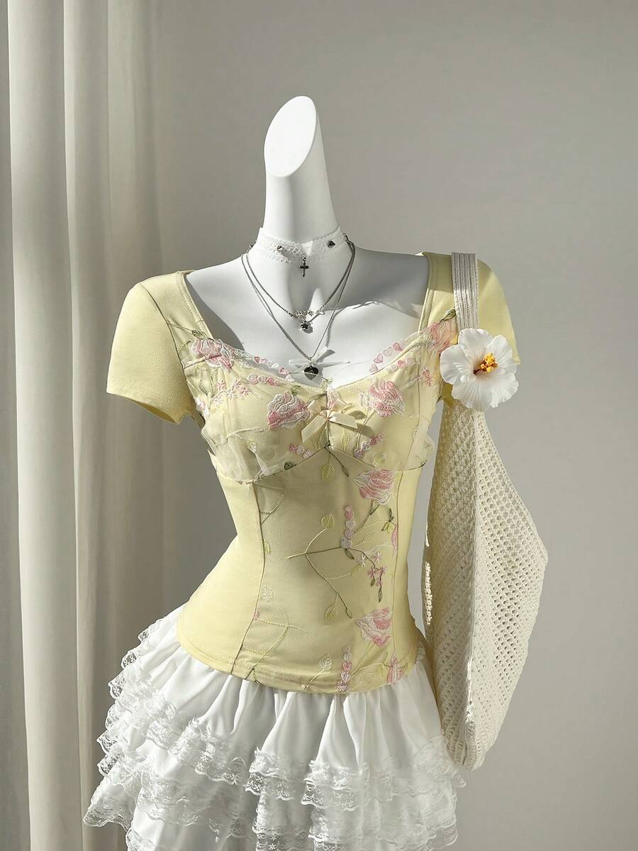 Women's pink short sleeve slim fit dress featuring a plant pattern, scoop neck, ruched appliques, and button front detail.