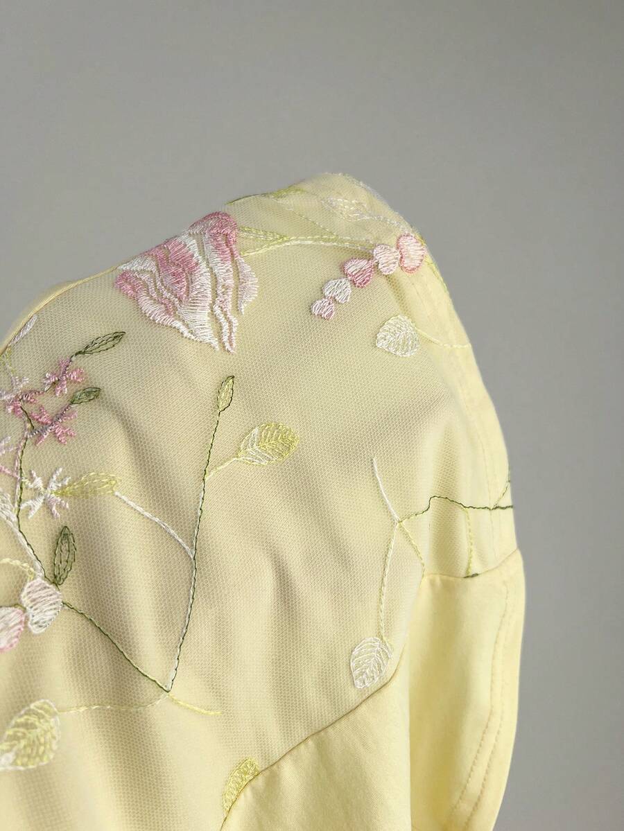 Women's pink short sleeve slim fit dress featuring a plant pattern, scoop neck, ruched appliques, and button front detail.