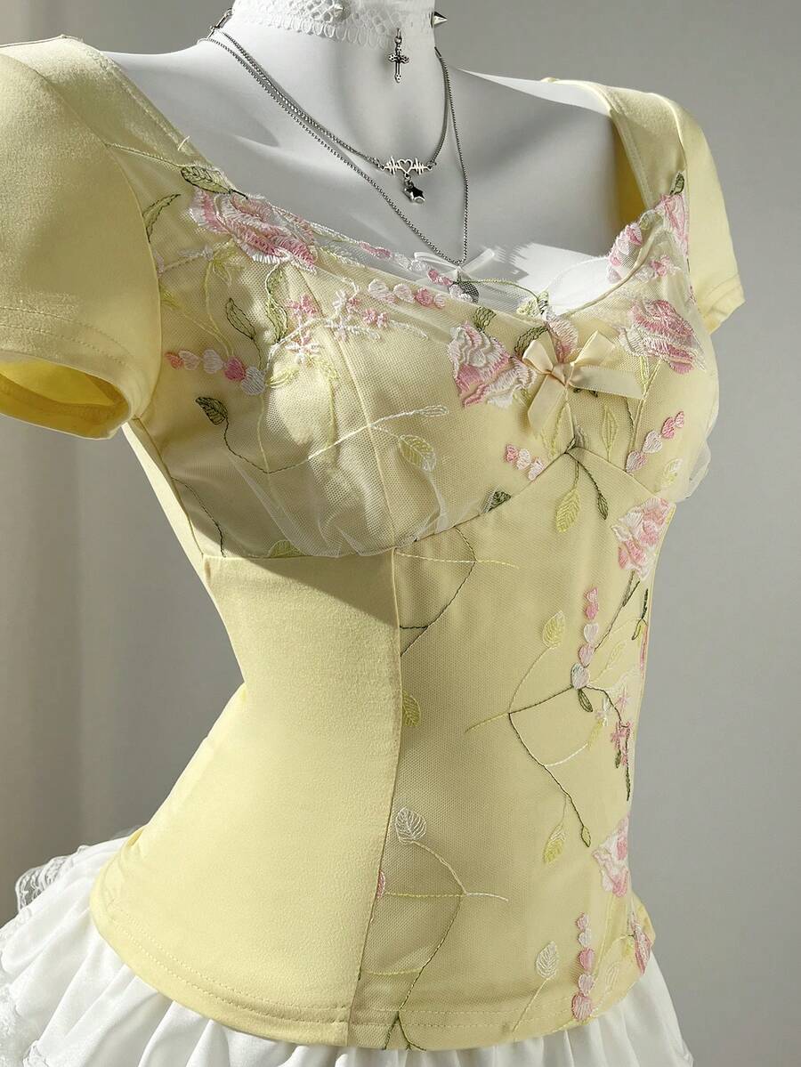 Women's pink short sleeve slim fit dress featuring a plant pattern, scoop neck, ruched appliques, and button front detail.