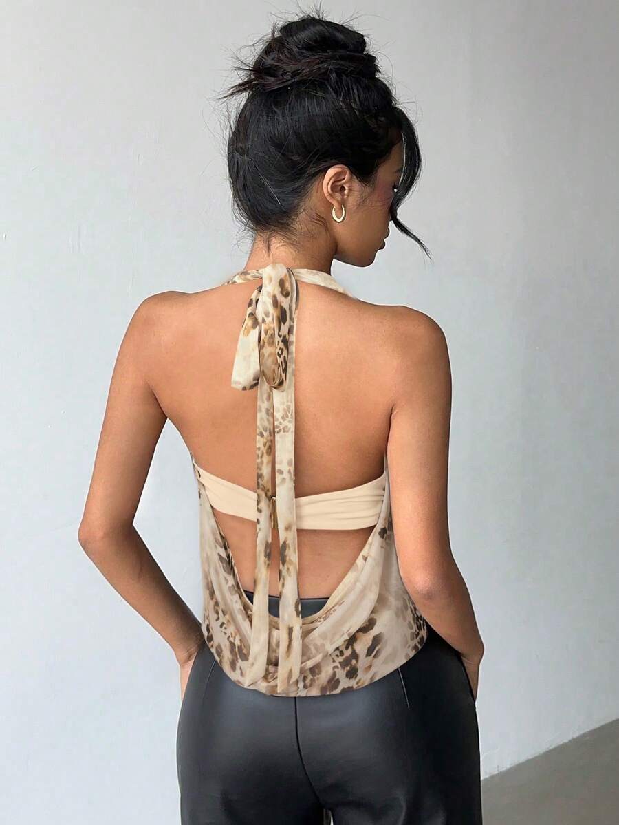 Brown and white polka dot semi-sheer halter camisole top with a plunging neckline, backless design, draped front, and metallic studded embellishments.