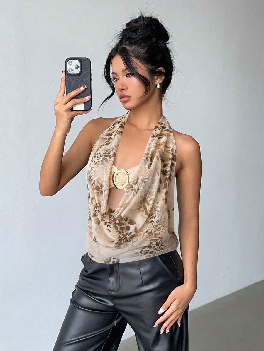 Brown and white polka dot semi-sheer halter camisole top with a plunging neckline, backless design, draped front, and metallic studded embellishments.