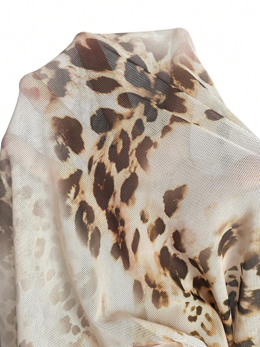 Brown and white polka dot semi-sheer halter camisole top with a plunging neckline, backless design, draped front, and metallic studded embellishments.