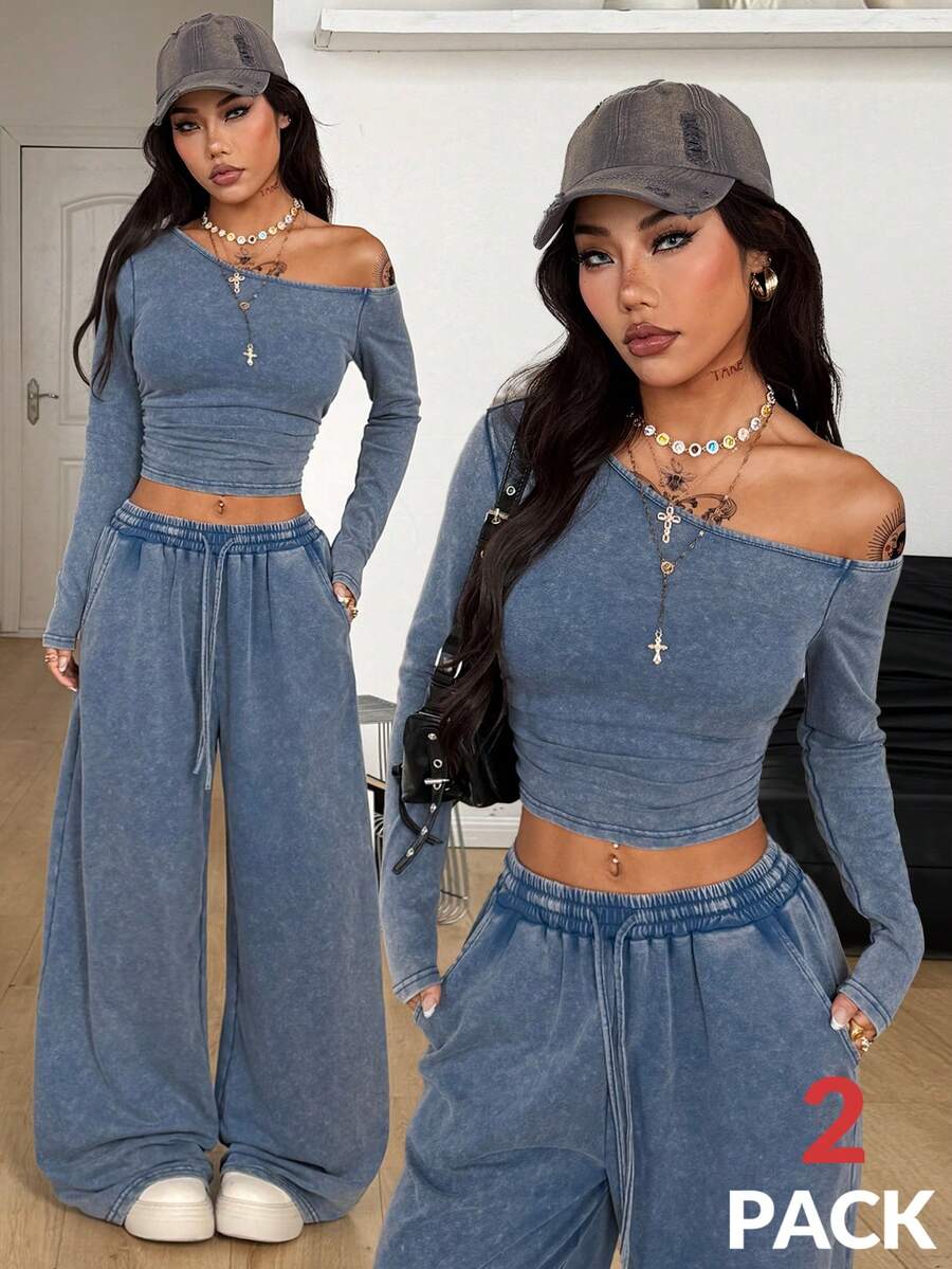 Women's two-piece knit lounge set featuring a black long sleeve asymmetrical crop top and matching high-waisted wide leg sweatpants.