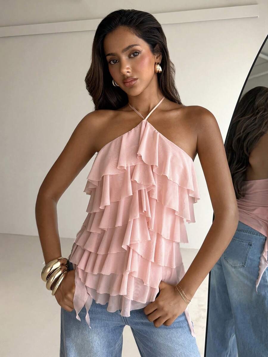 Women's sleeveless halter neck top featuring tiered ruffle layers, a backless cut, and an asymmetrical hem.