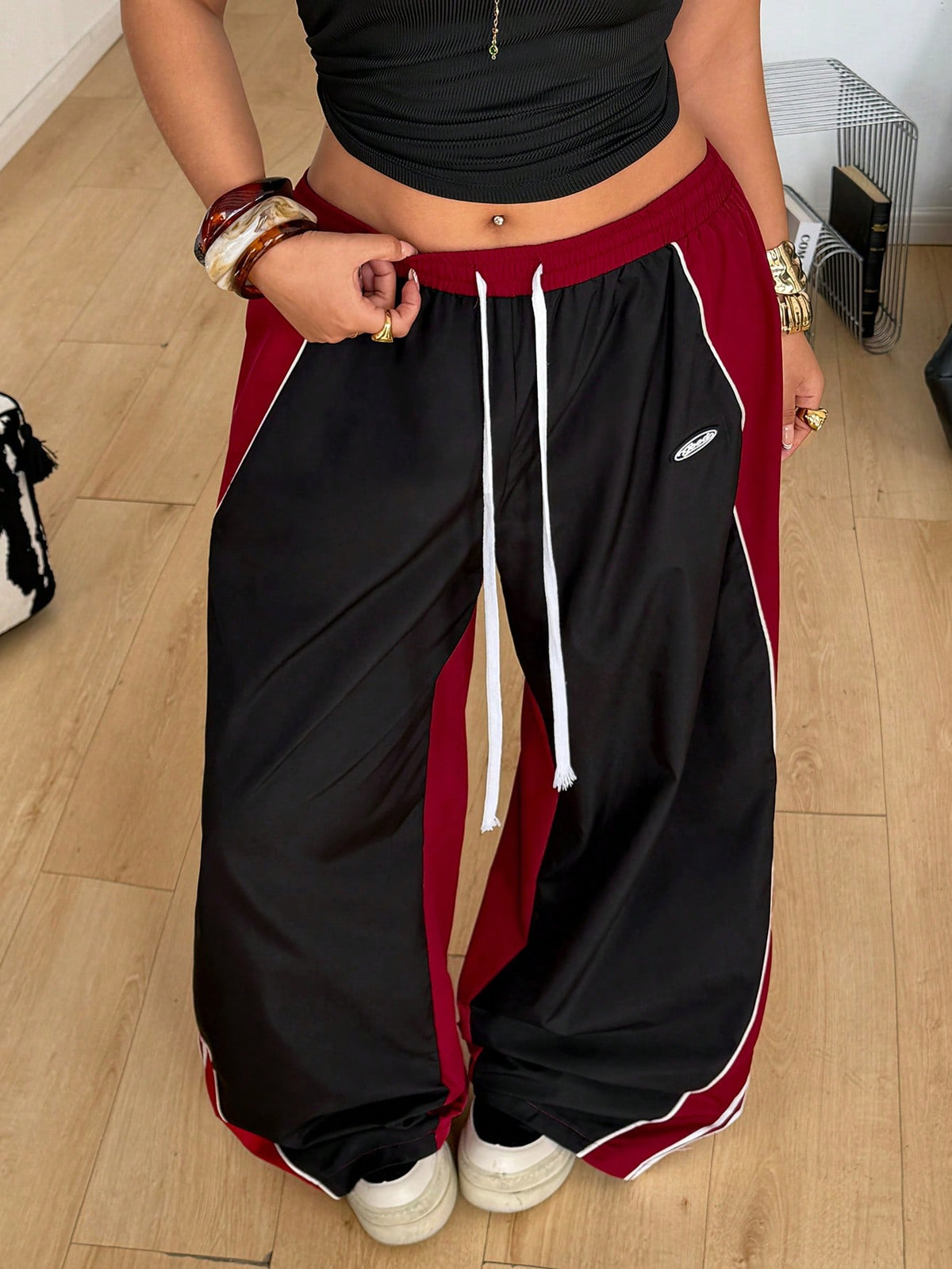 Women's plus size loose straight leg pants featuring a black and white color block design with side stripes and an elastic drawstring waist.