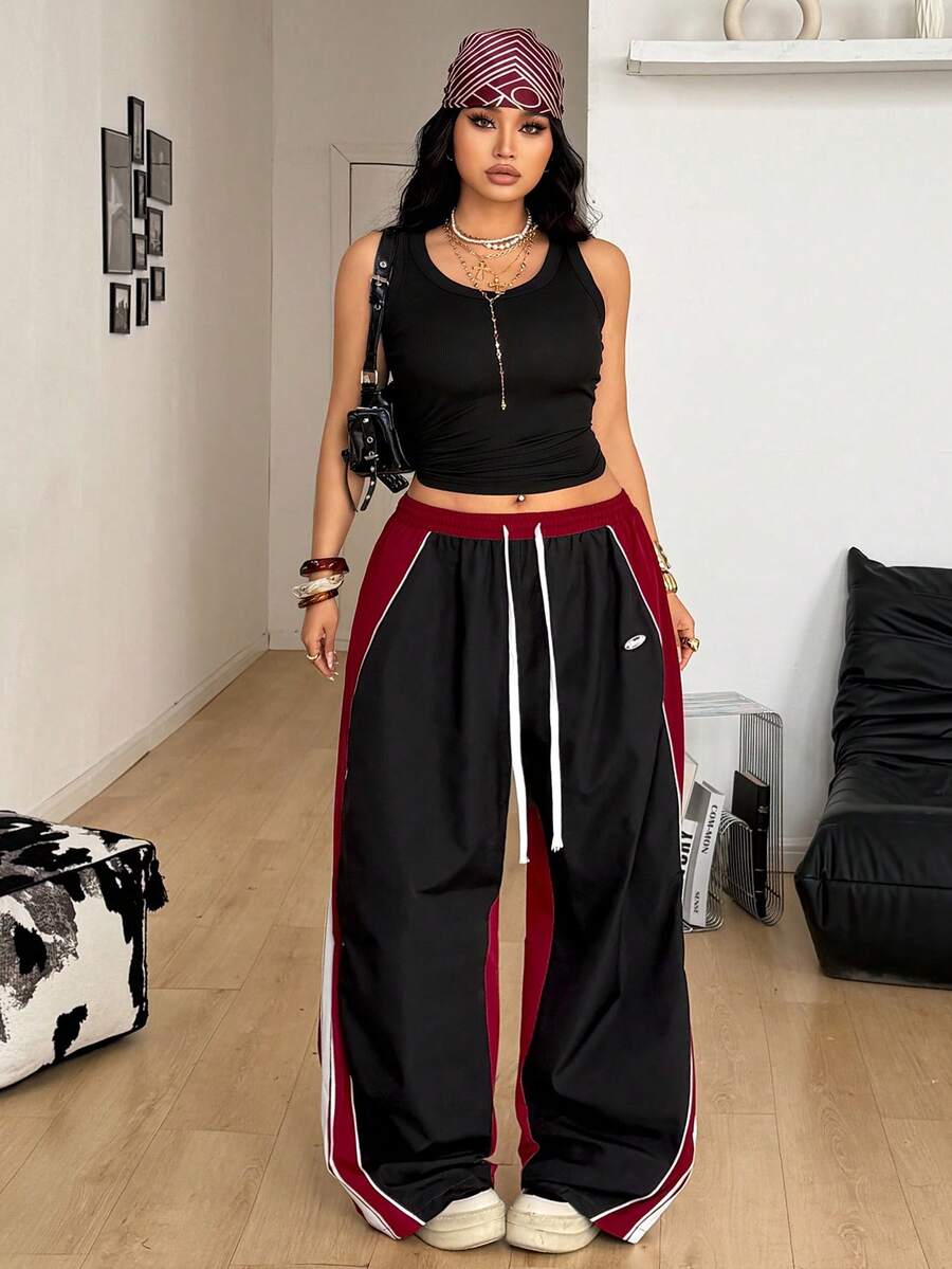 Women's plus size loose straight leg pants featuring a black and white color block design with side stripes and an elastic drawstring waist.