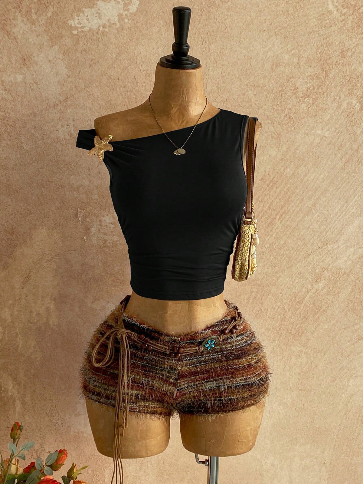 Women's black fuzzy knit two-piece set with an asymmetrical crop camisole top featuring ruched detail and cutout back, paired with matching mini shorts.