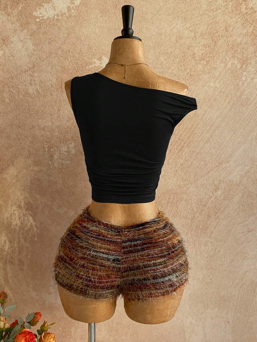 Women's black fuzzy knit two-piece set with an asymmetrical crop camisole top featuring ruched detail and cutout back, paired with matching mini shorts.
