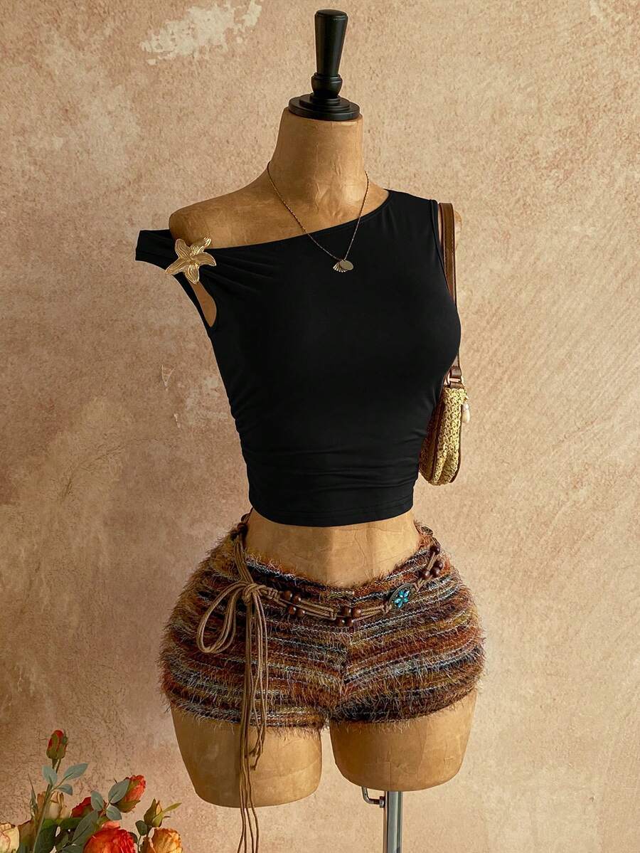 Women's black fuzzy knit two-piece set with an asymmetrical crop camisole top featuring ruched detail and cutout back, paired with matching mini shorts.