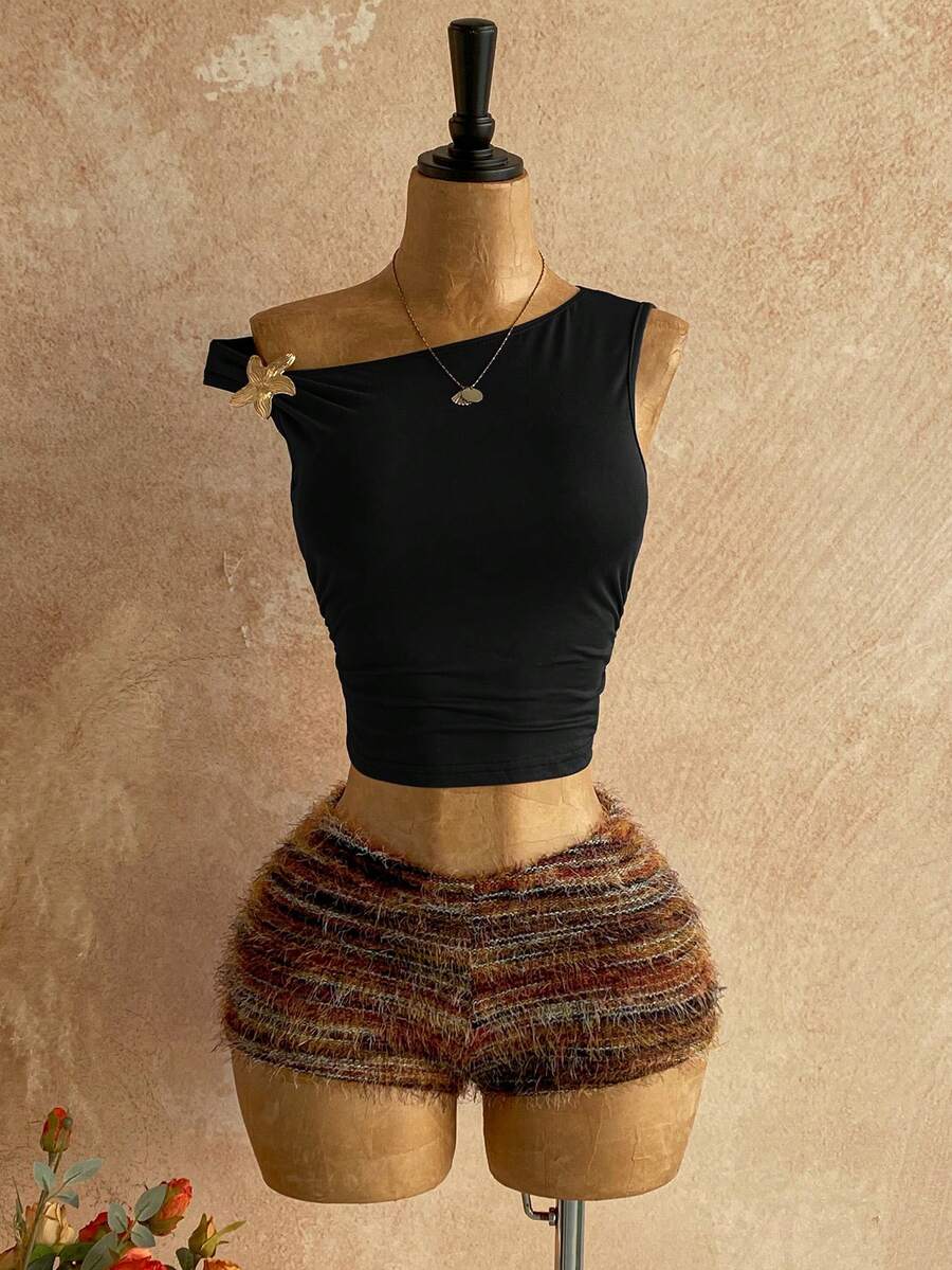 Women's black fuzzy knit two-piece set with an asymmetrical crop camisole top featuring ruched detail and cutout back, paired with matching mini shorts.