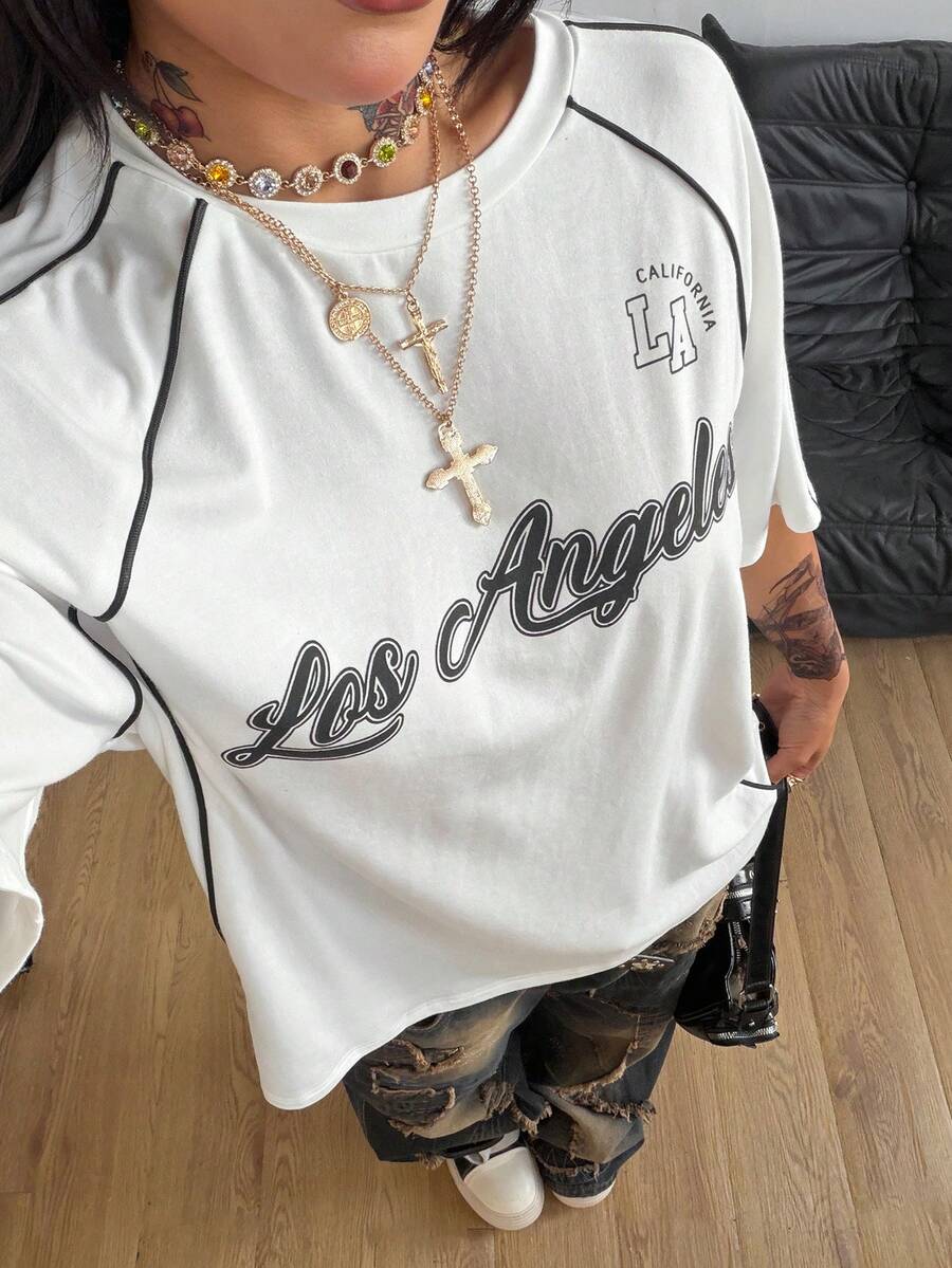 Yellow oversized graphic t-shirt featuring Brazil letter print on the front with contrast raglan sleeves and side stripe detailing.