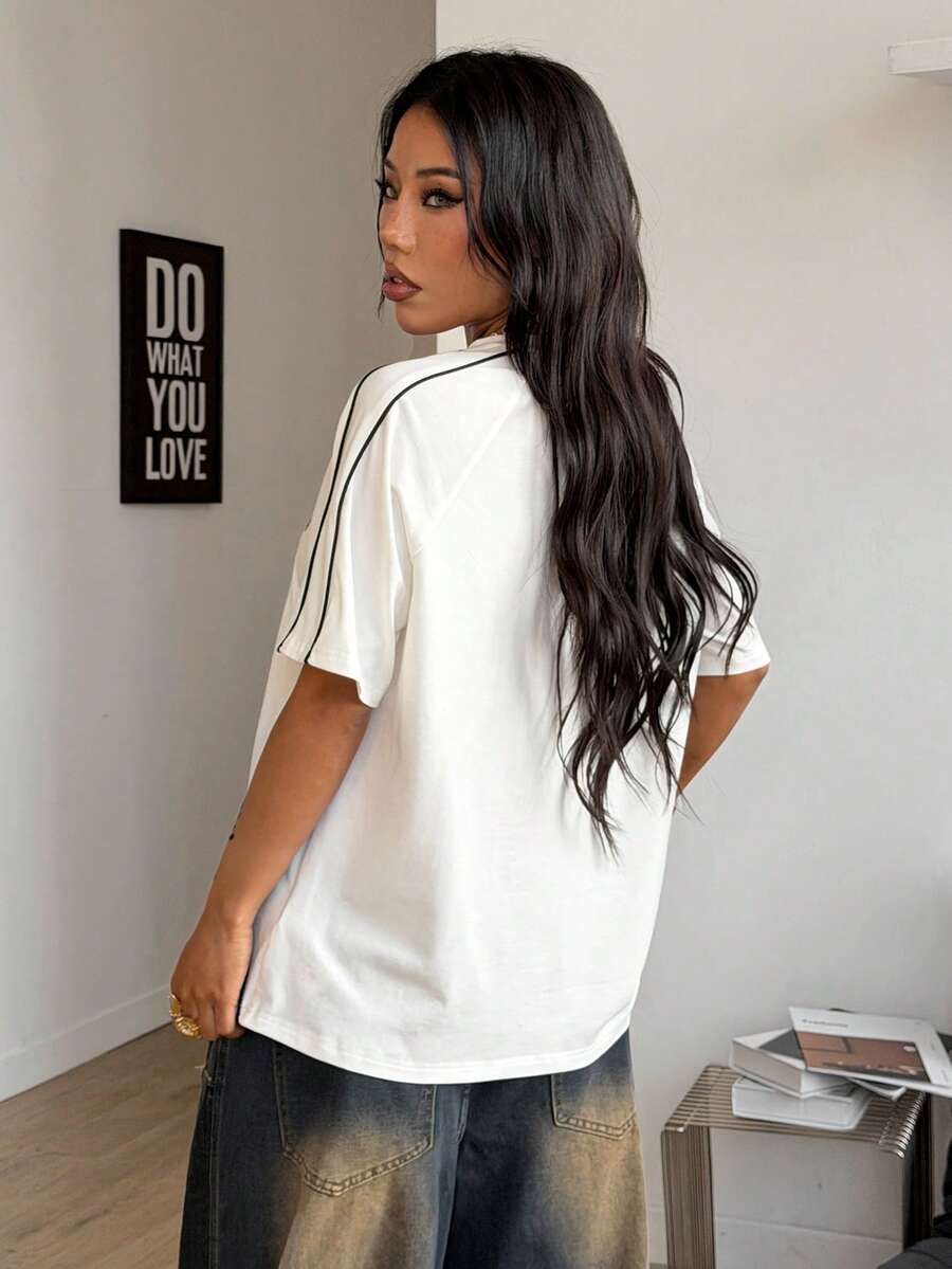 Yellow oversized graphic t-shirt featuring Brazil letter print on the front with contrast raglan sleeves and side stripe detailing.