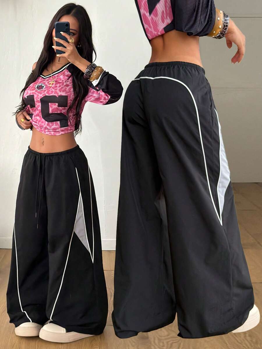 Women's wide leg parachute pants featuring an army green color-blocked design with side stripes and an adjustable drawstring waist.