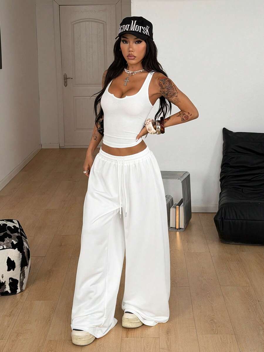 Women's two-piece casual outfit featuring a slim-fit camisole tank top with ruffle trim and button front paired with high-waisted wide leg pants.