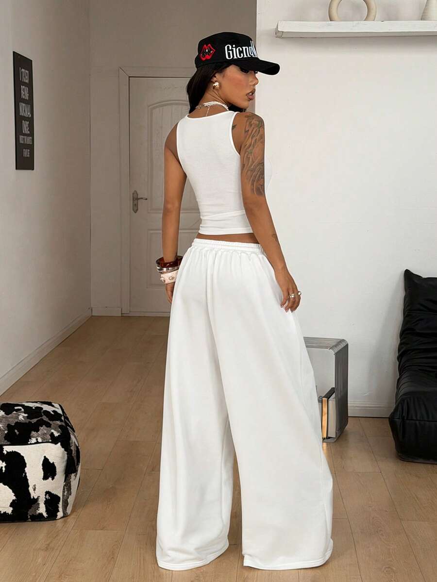 Women's two-piece casual outfit featuring a slim-fit camisole tank top with ruffle trim and button front paired with high-waisted wide leg pants.