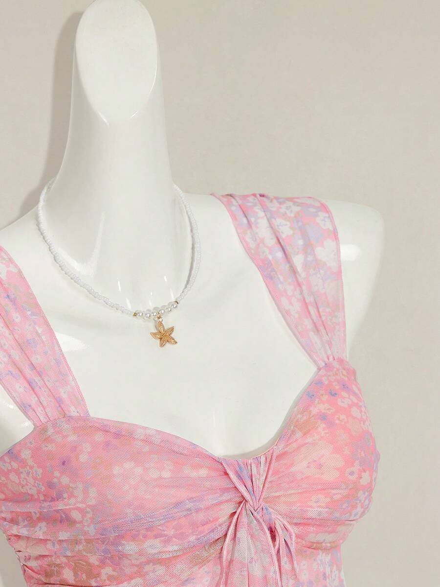 Women's white cherry print cami top with wide straps, ruched knot detail, and an asymmetrical hem