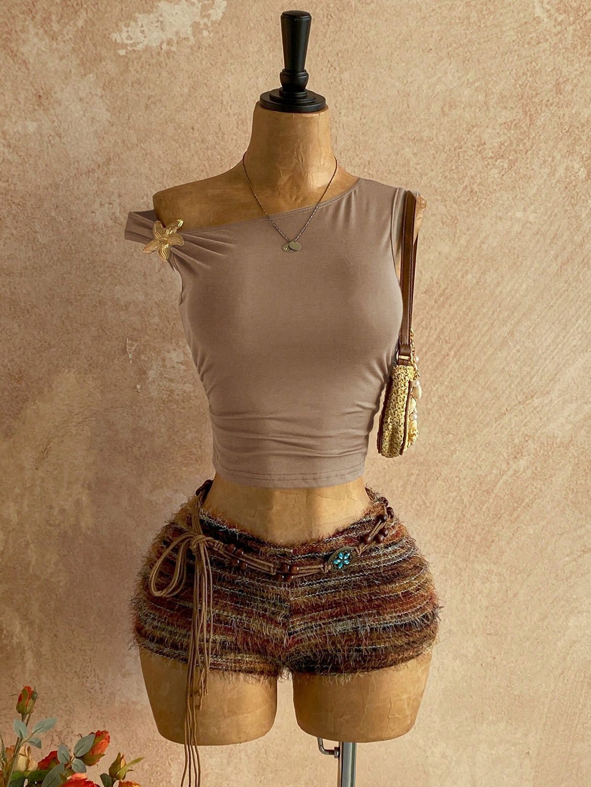 Women's black fuzzy knit two-piece set with an asymmetrical crop camisole top featuring ruched detail and cutout back, paired with matching mini shorts.