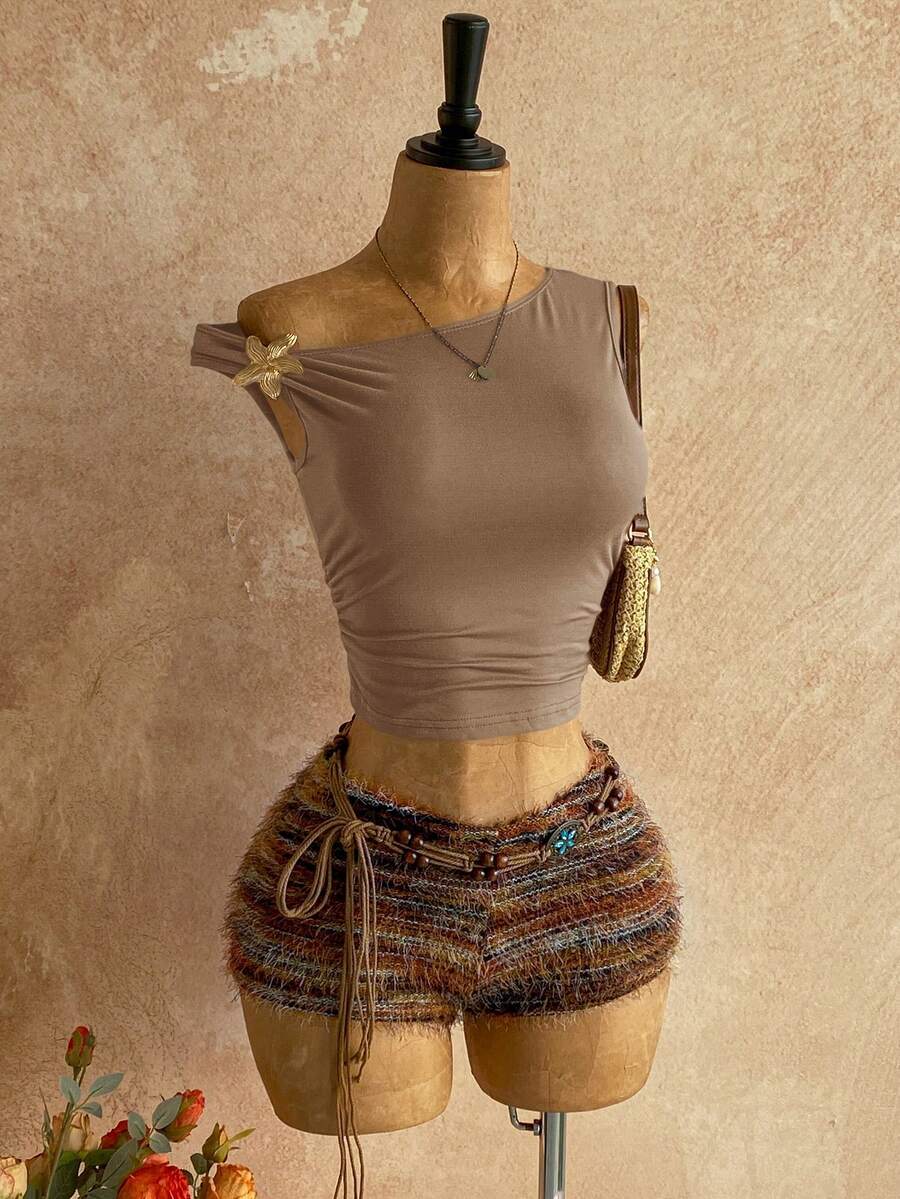 Women's black fuzzy knit two-piece set with an asymmetrical crop camisole top featuring ruched detail and cutout back, paired with matching mini shorts.