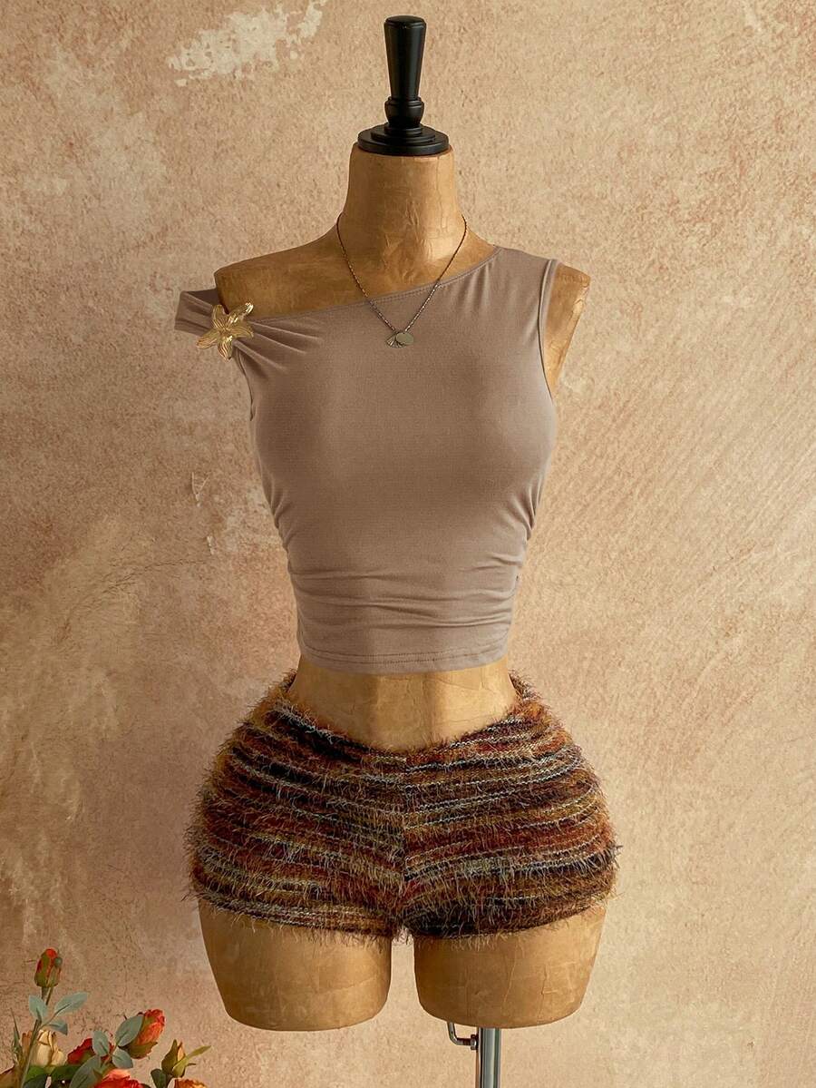 Women's black fuzzy knit two-piece set with an asymmetrical crop camisole top featuring ruched detail and cutout back, paired with matching mini shorts.
