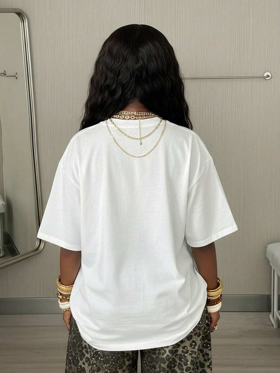 Women's oversized graphic crew neck t-shirt made of 100% white cotton knitted fabric with drop shoulder half sleeves.
