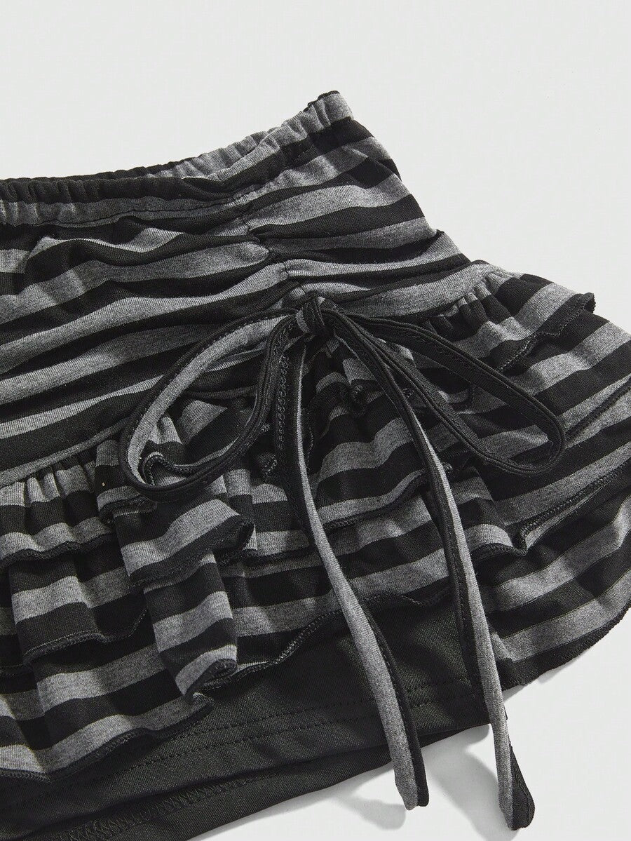 Women's black low-waist mini skirt with drawstring tie, ruched details, lace trim, layered ruffle hem, and asymmetric styling