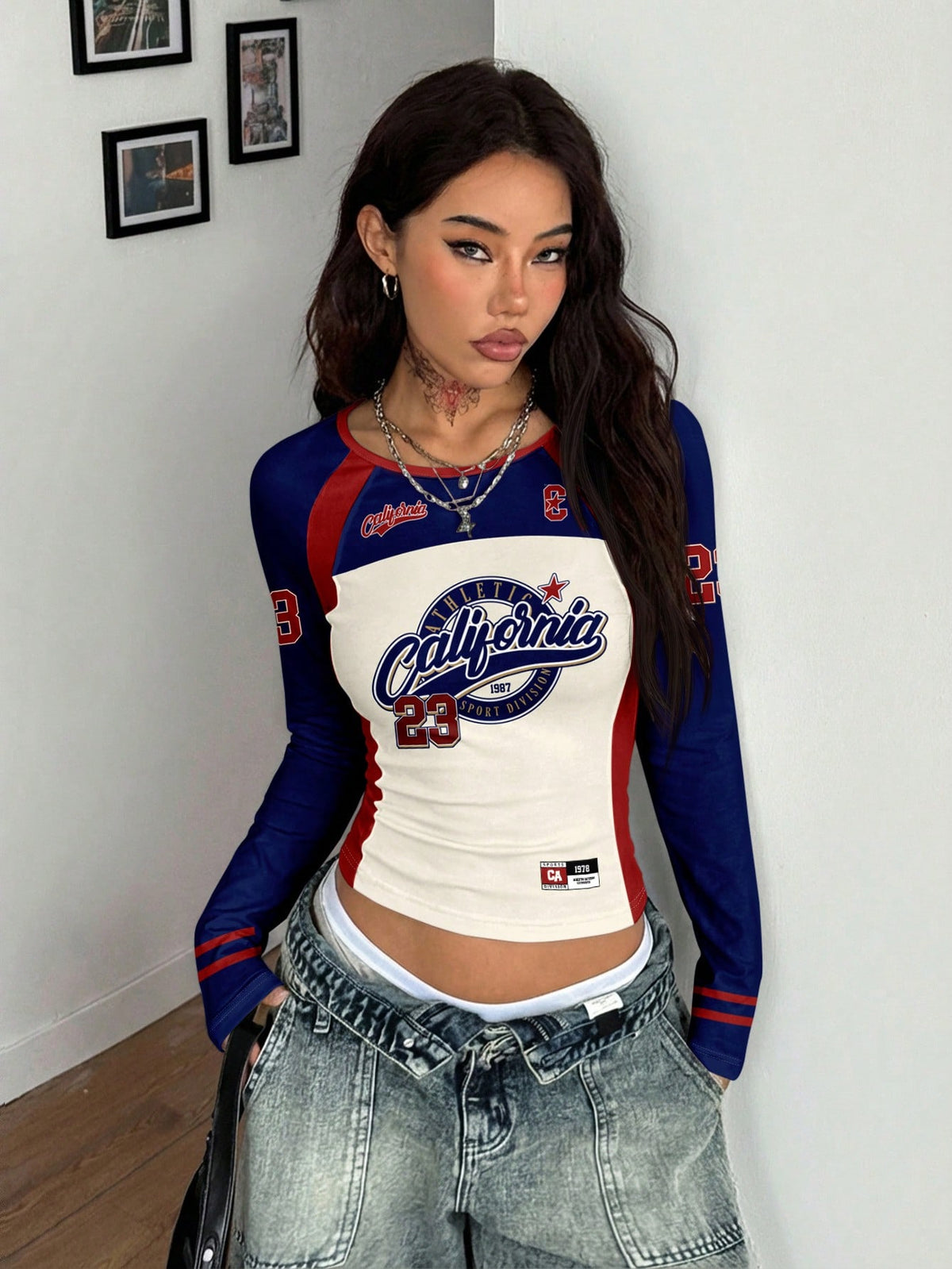 Women's slim fit long sleeve raglan t-shirt with collegiate letter graphic print, round neck, and contrast binding.