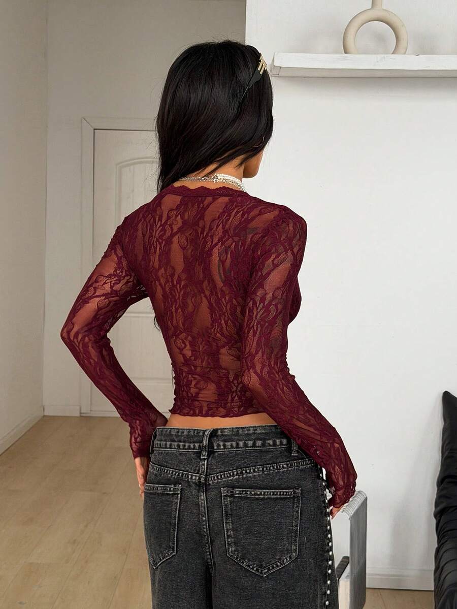 Women's polka dot sheer mesh crop blouse featuring contrast scallop lace trim along the V-neckline and long sleeves in a slim fit silhouette.