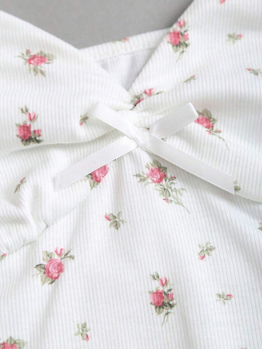Women's short sleeve knit top with a sweetheart neckline and ruched twist knot front detail.