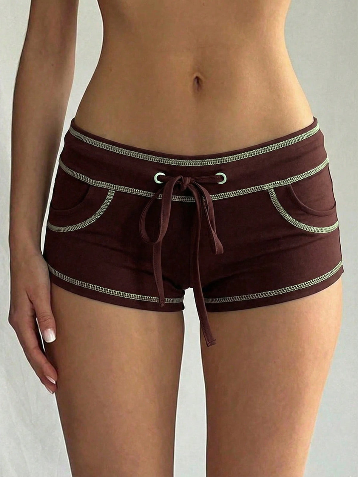 Women's low waist track shorts with drawstring waist, zipper detail, and mini length in a casual skinny fit