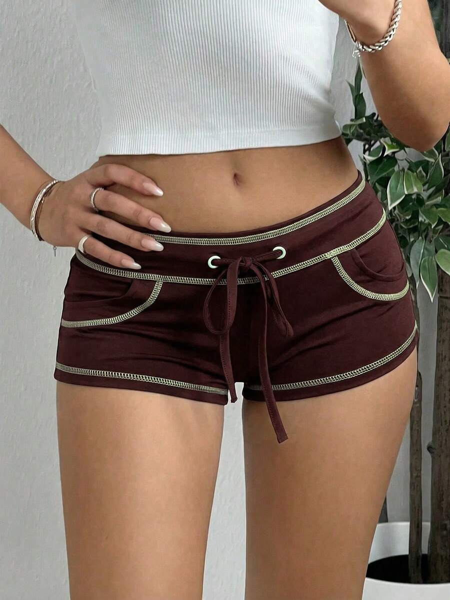 Women's low waist track shorts with drawstring waist, zipper detail, and mini length in a casual skinny fit