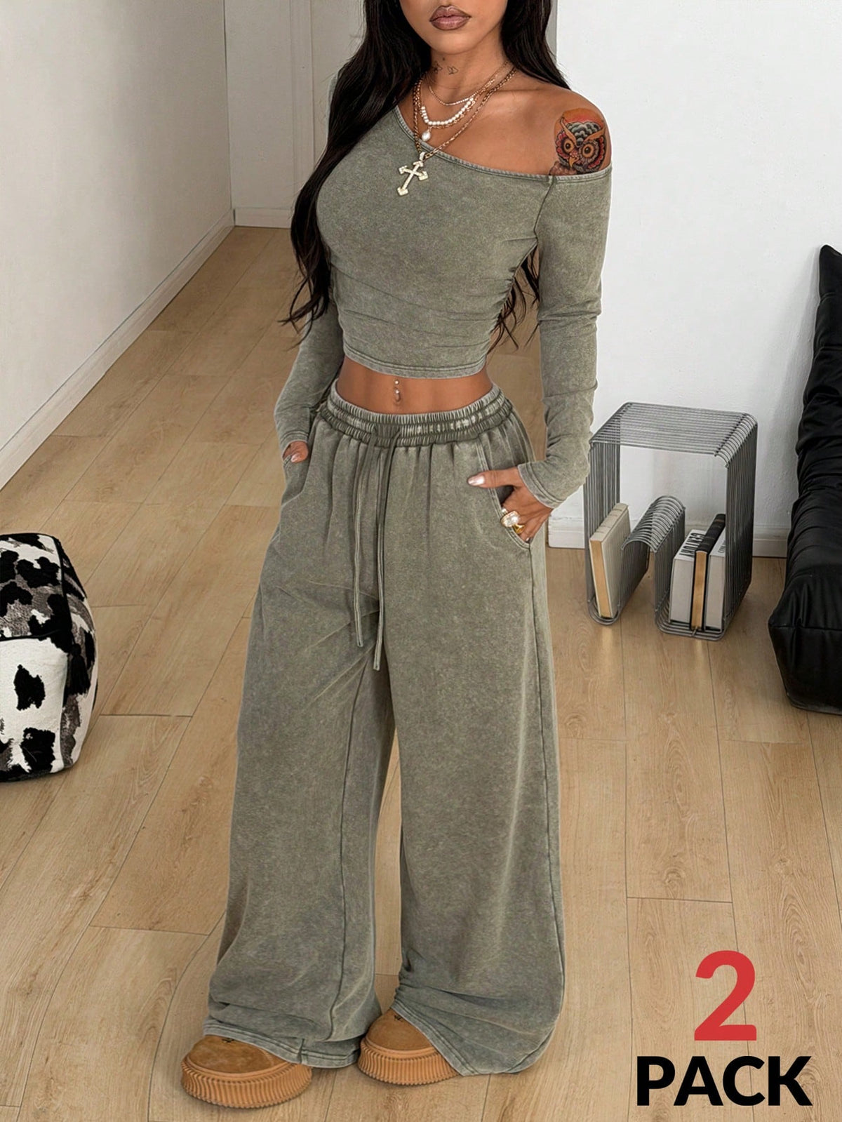 Women's two-piece knit lounge set featuring a black long sleeve asymmetrical crop top and matching high-waisted wide leg sweatpants.