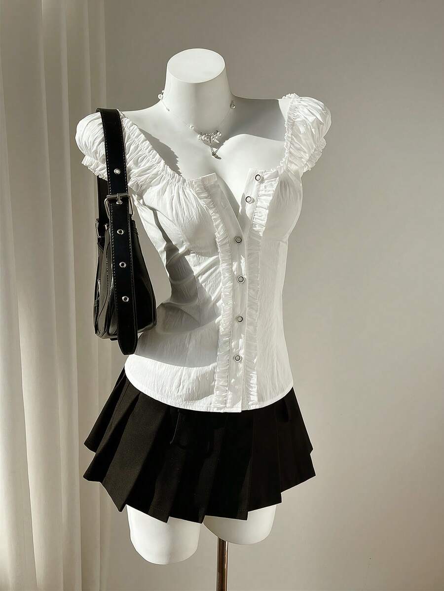 Women's black off-shoulder cap sleeve blouse with ruffled detailing and a tie-back design.