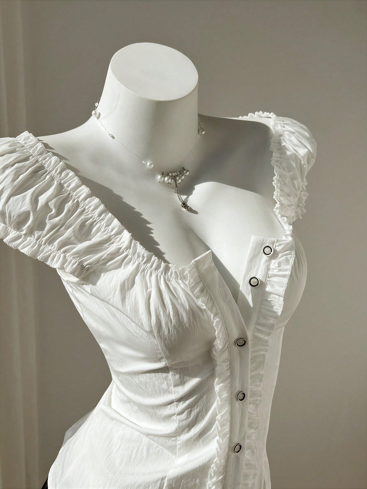 Women's black off-shoulder cap sleeve blouse with ruffled detailing and a tie-back design.