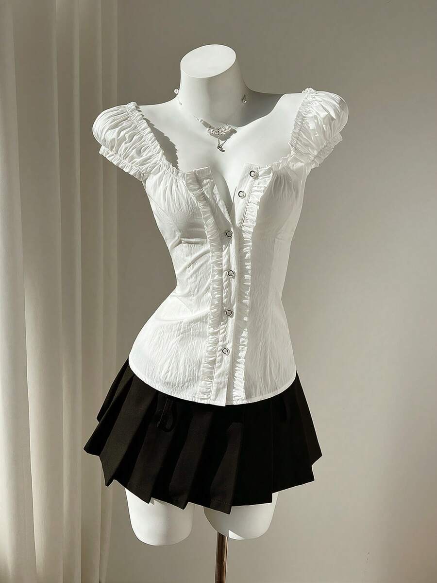 Women's black off-shoulder cap sleeve blouse with ruffled detailing and a tie-back design.